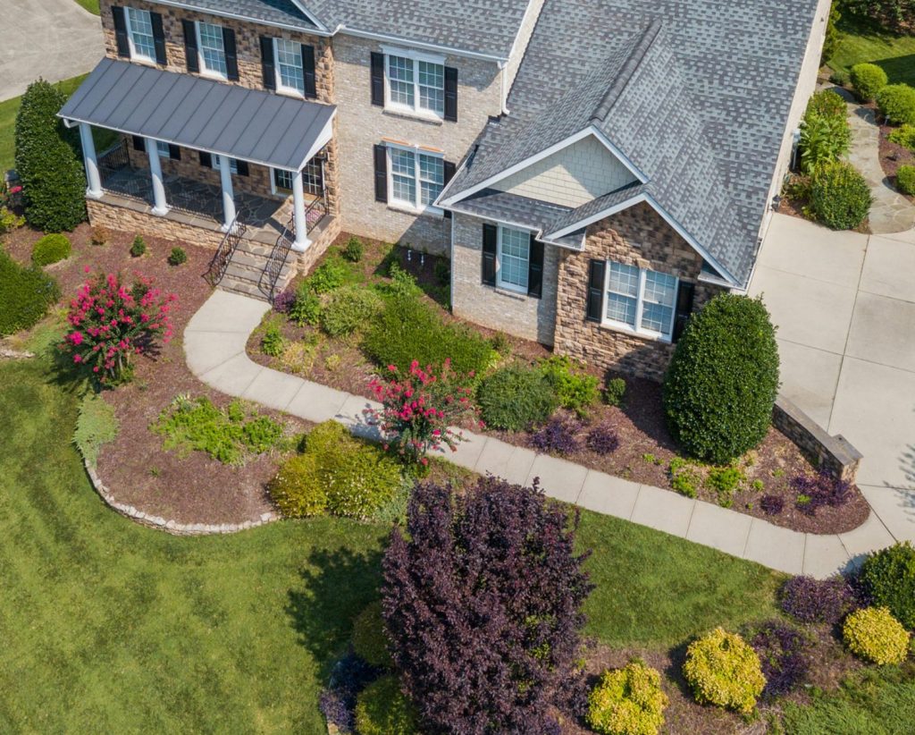 Bird's-eye view of a beautiful suburban home in Raleigh, NC, with lush landscaping.